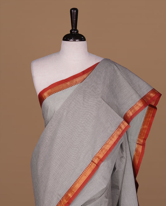Grey Colour Chettinad cotton saree featuring elegant plain body , complemented by contrast Brown colour with simple  traditional border, comes with matching blouse piece.