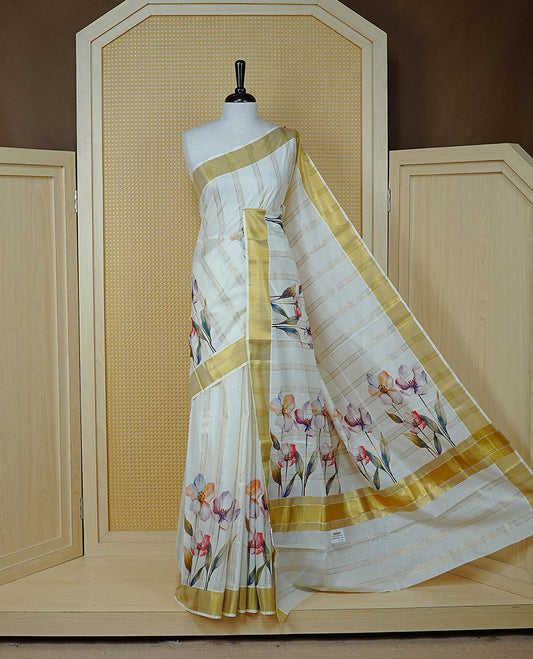 Cream Colour Cotton Kerala Sree Featuring Gold Zari Stripes On Body, Enrich Gold Zari With Floral Printed Border & Pallu, Paired With Matching Blouse Piece.