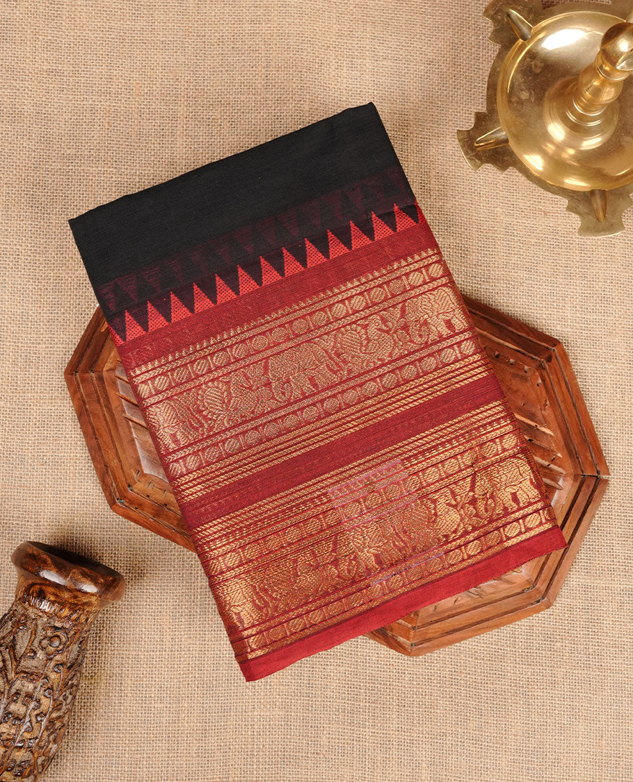 Black colour chettinad cotton saree featuring plain body, contrast maroon colour with traditional gold zari border paired with matching blouse.