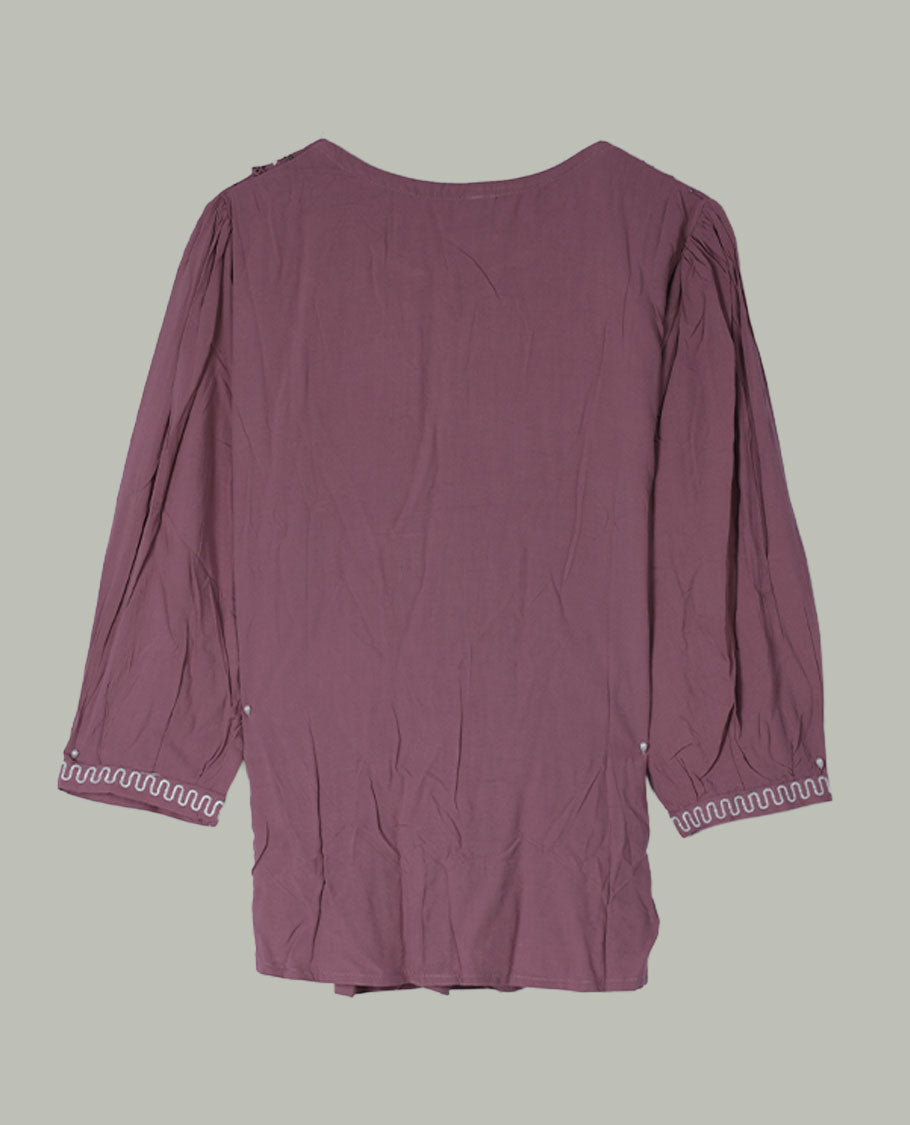 Mauve three-quarter sleeve tunic top with round neckline, intricately patterned embroidered yoke, front pleats, side lace inserts, and scalloped embroidered cuffs.