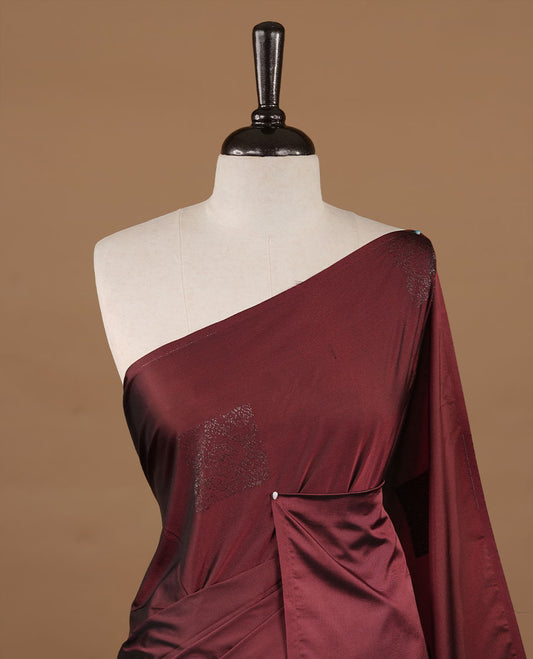Maroon colour soft silk saree features a sleek borderless design with intricate antique zari motifs, flowing into a striking contrast biscuit orange pallu and a matching blouse piece.