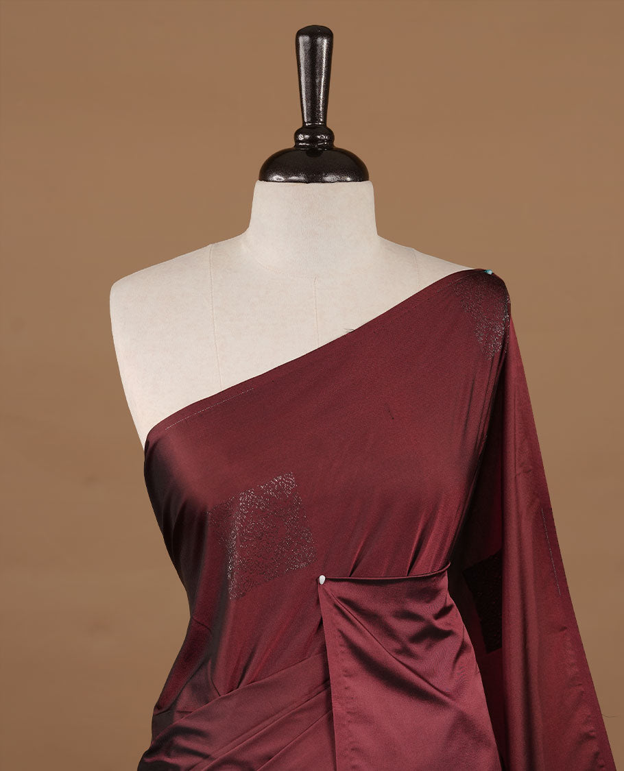 Maroon colour soft silk saree features a sleek borderless design with intricate antique zari motifs, flowing into a striking contrast biscuit orange pallu and a matching blouse piece.