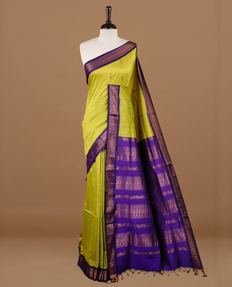 Green colour kalyani cotton saree featuring gold zari motifs on body, highlighting contrast Indigo colour with Antique gold zari border, paired with matching blouse piece.