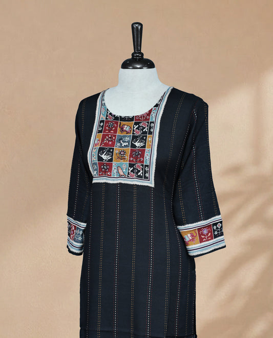 Black colored Kurti featuring vertical dotted lines across the body, a round neckline adorned with animal and floral prints and thread work, and 3/4 sleeves.