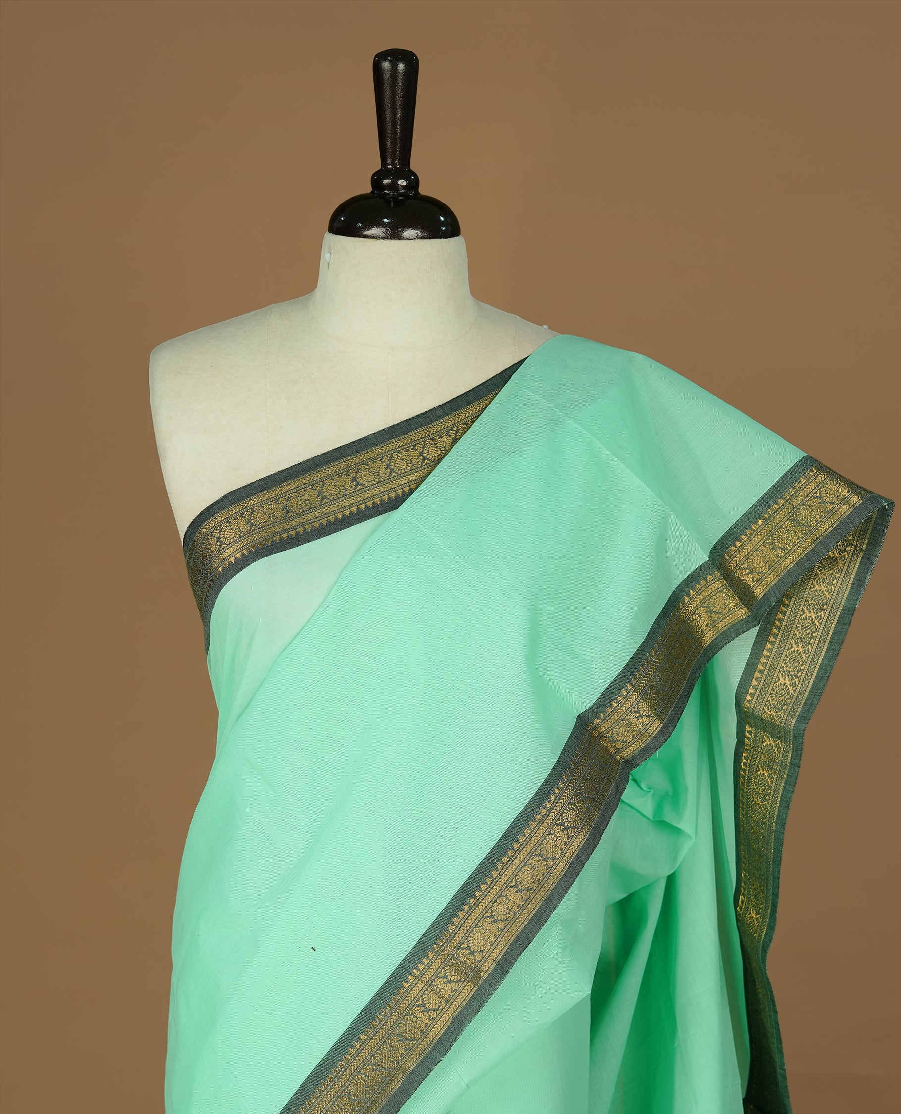 Mint Colour Chettinad cotton saree featuring elegant plain body , complemented by contrast Greyish black colour with simple  traditional border, comes with matching blouse piece.