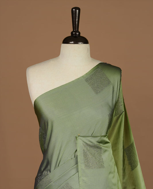 Seafoam green soft silk saree features a sleek borderless design with intricate antique zari motifs, flowing into a seamless self colored pallu and a matching blouse piece.
