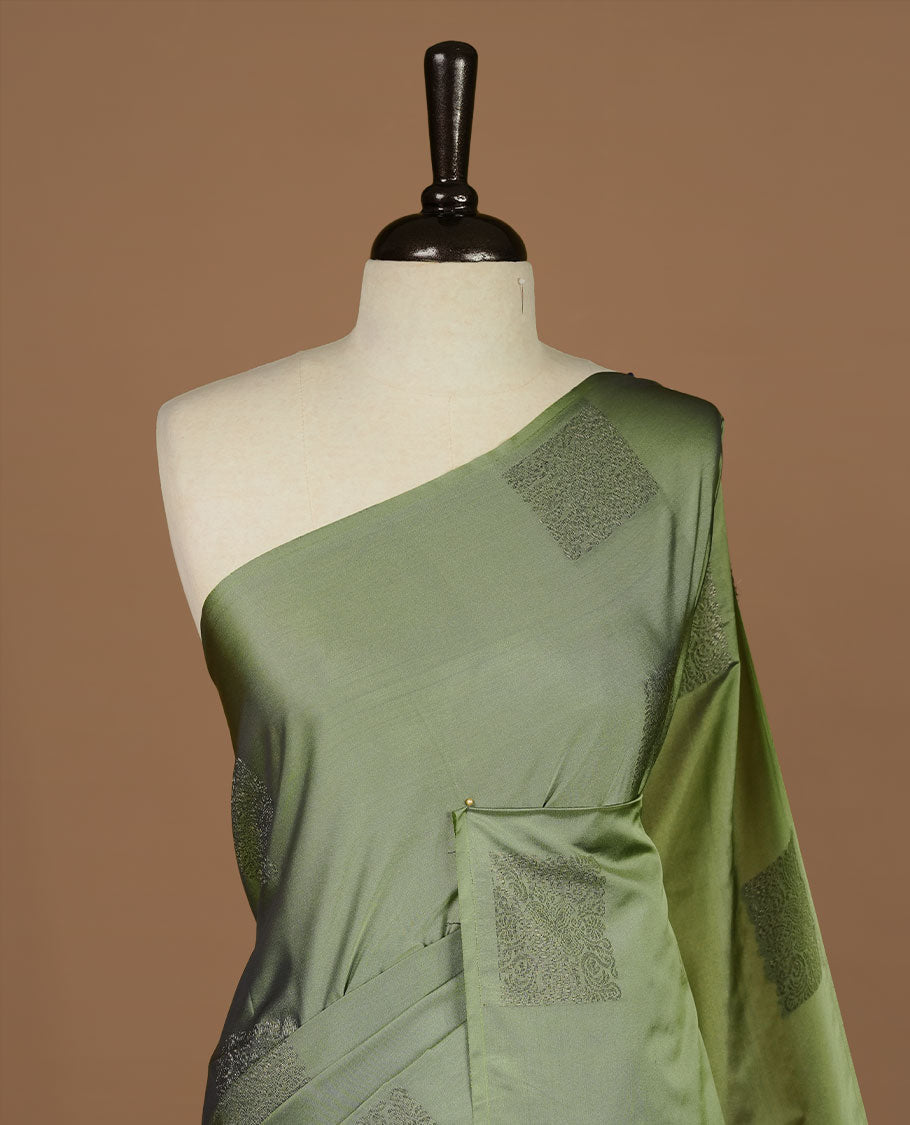 Seafoam green soft silk saree features a sleek borderless design with intricate antique zari motifs, flowing into a seamless self colored pallu and a matching blouse piece.