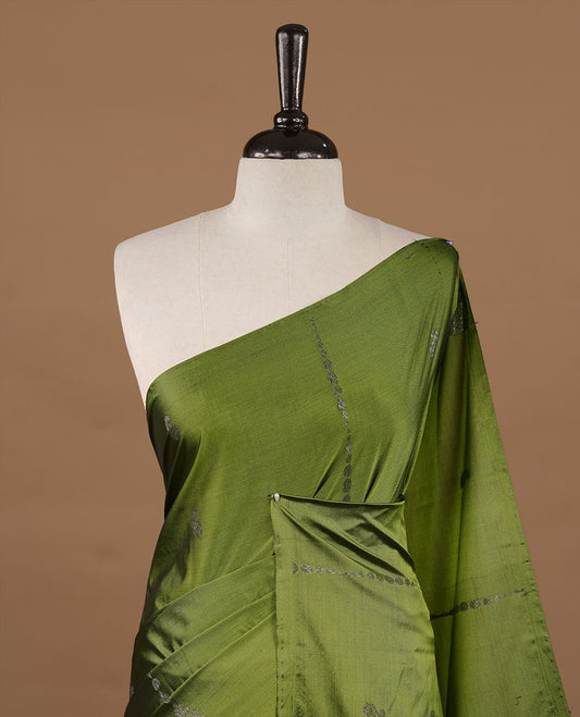 Olive colour soft silk saree features a sleek borderless design with intricate antique zari motifs, flowing into a striking contrast deep purple pallu and a matching blouse piece.
