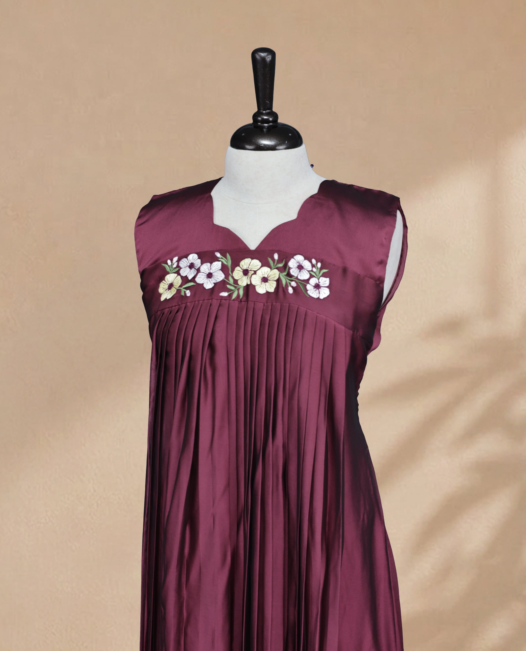 Wine Berry Coloured Sleeveless Kurti Featuring a Designed Neckline, Floral Embroidery on the Body