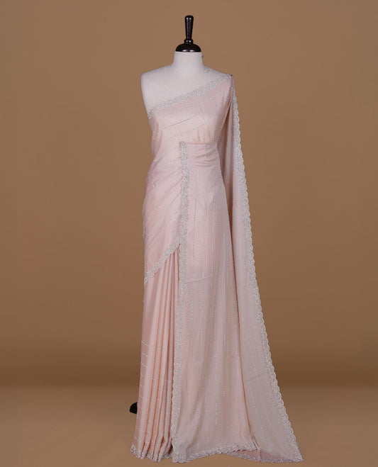 Light Peach colour designer saree featuring white stone stripes on body, highlighting white stone with scalp border, paired with matching blouse piece.