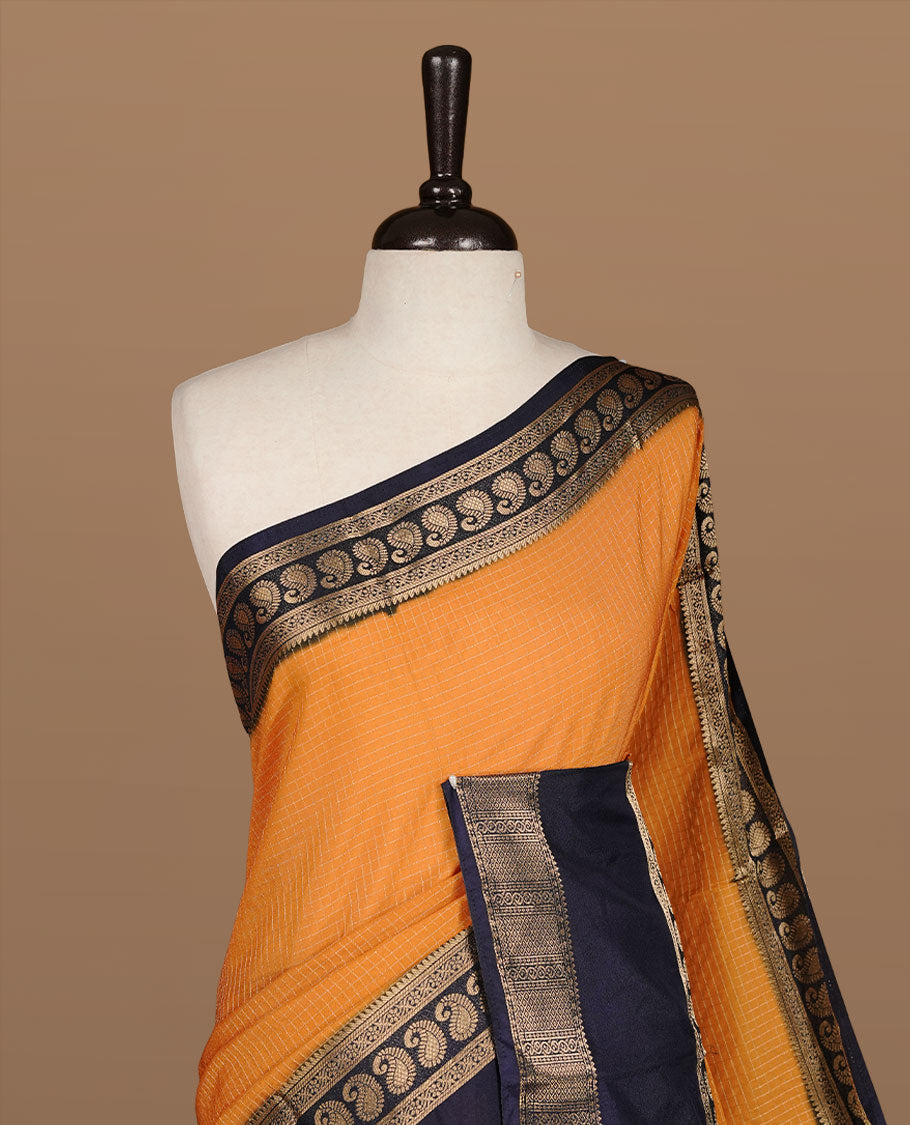 Mustard colour semi georgette saree featuring gold zari check pattern on body, complemented by contrast Blue colour with zari border, paired with matching blouse piece.