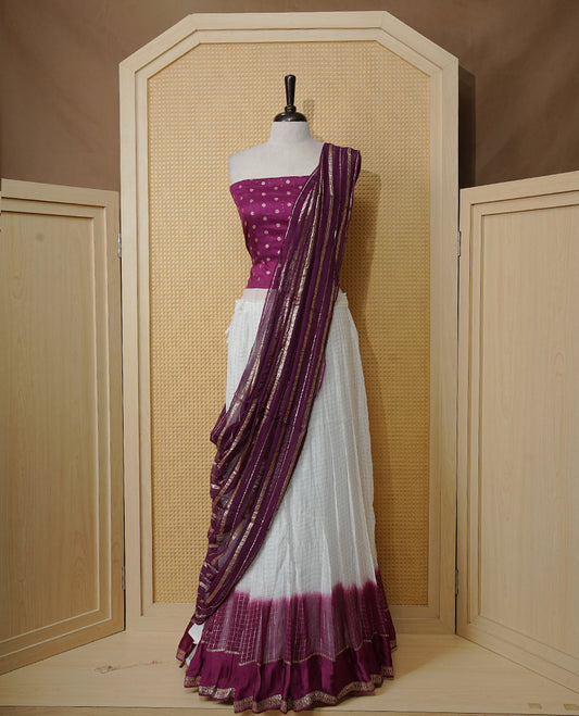 Off white colour Semi stitched dhavani set featuring Gold zari check pattern with contrast Purple border skirt, paired with matching blouse & dupatta.