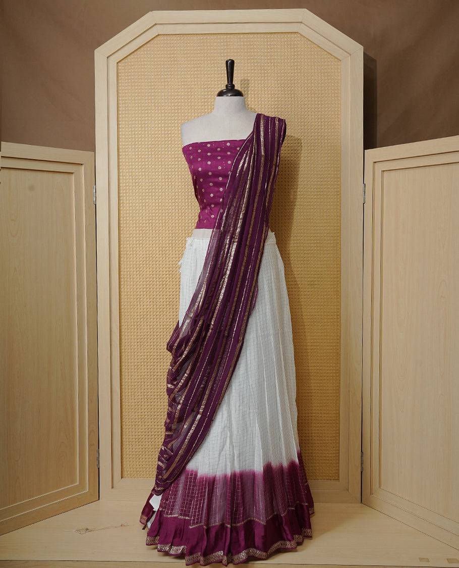 Off white colour Semi stitched dhavani set featuring Gold zari check pattern with contrast Purple border skirt, paired with matching blouse & dupatta.