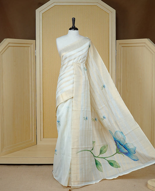 Cream Colour Organza Kerala Saree Featuring Gold Zari Strips with Floral Printed Motifs  On The Body,Paired With A Matching Blouse Piece.
