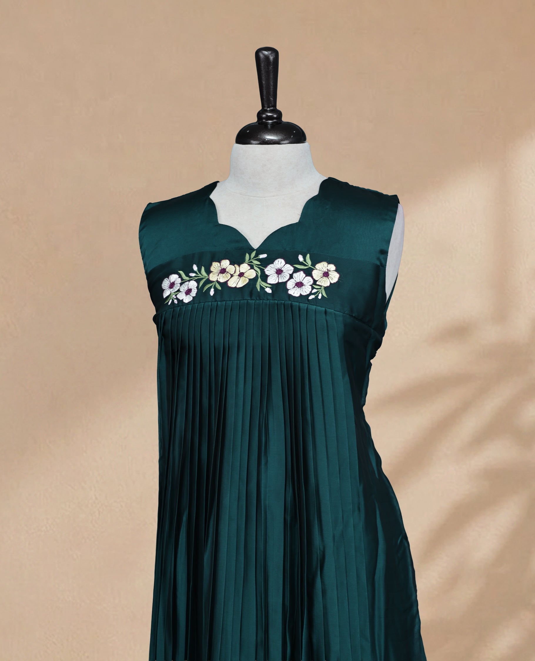 Bottle Green Coloured Sleeveless Kurti Featuring a Designed Neckline, Floral Embroidery on the Body