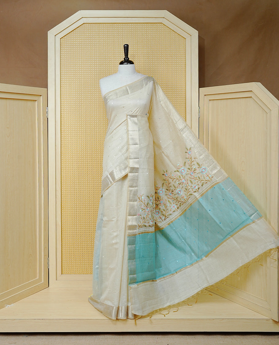 Cream Colour Tussar Kerala Saree Featuring Elegant Mirror Work on the Body, Enhanced with a Light Gold Zari Border, Floral Thread Work, and a Blue & Gold Zari Pallu, Paired with a Matching Blouse Piece
