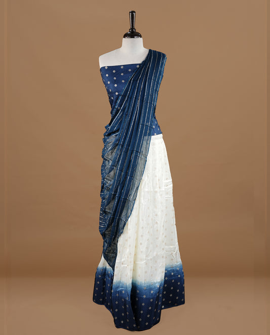 Off white colour semi stitched half saree featuring elegant zari buttas on the body, paired with a contrast blue border and matching motifs dupatta,paired with matching blouse piece.