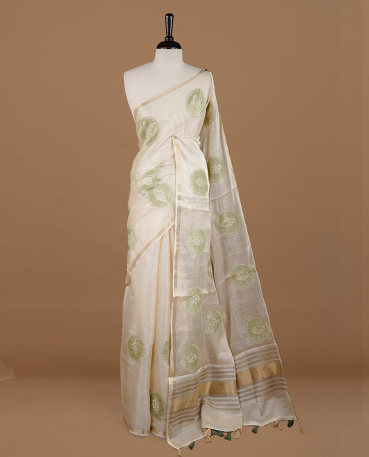 Cream colour Tussar saree featuring green colour circle pattern with chikankari embroidery work, highlighting gold zari simple border, paired with matching unstitched blouse.