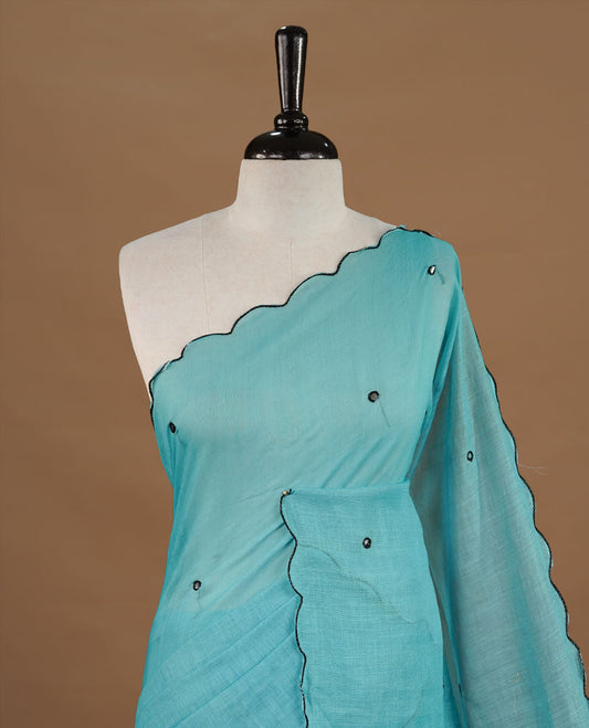Aqua colour Semi Linen saree featuring mirror work with intricate thread detailing, enhanced by a stylish scallop border. Comes without a blouse piece.
