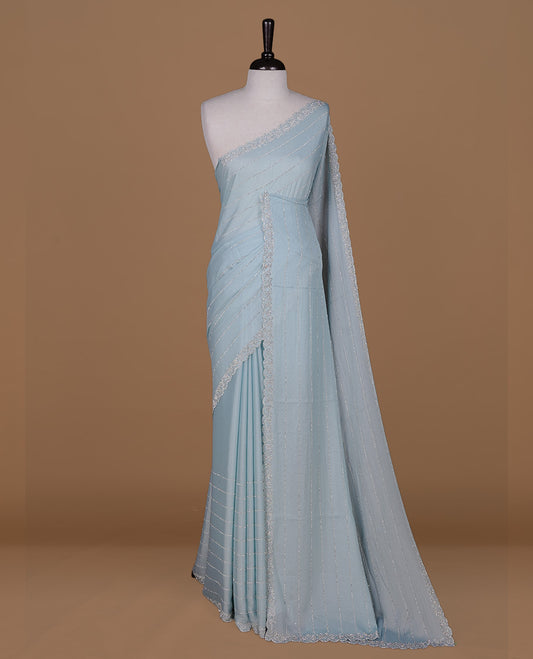 Mint colour designer saree featuring white stone stripes on body, highlighting white stone with scalp border, paired with matching blouse piece.
