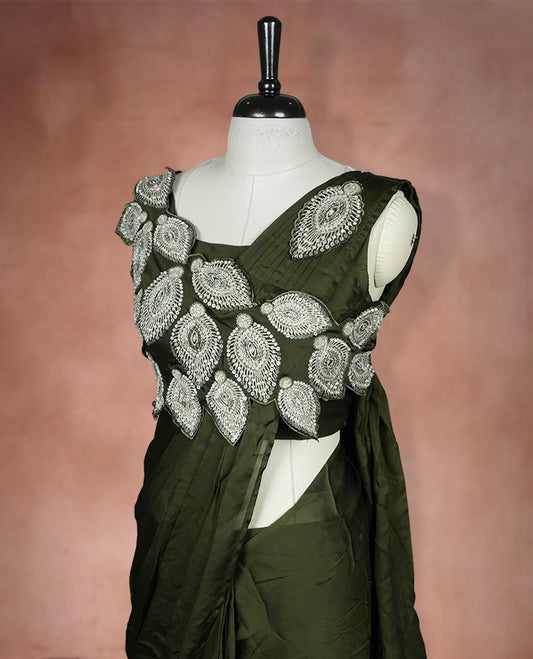 Dark olive colour ready to wear saree featuring bold silver applique embroidery on the drape, paired with a sculpted matching blouse