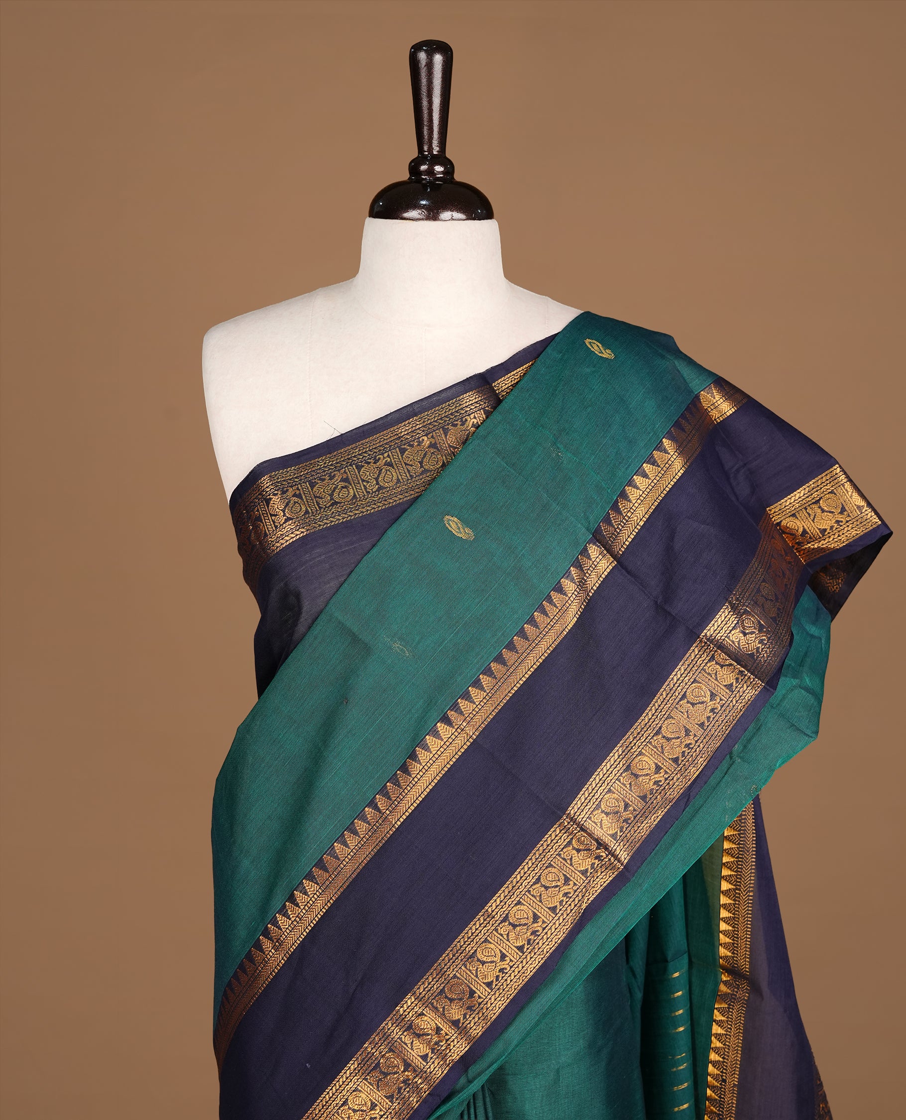 Dark green Colour Chettinad cotton saree featuring Godl zari motifs on body , complemented by contrast blue colour with traditional border, comes with matching blouse piece.