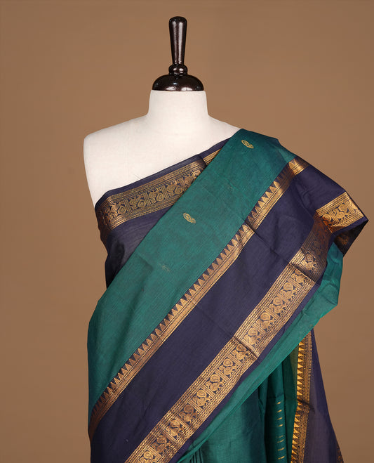 Dark green Colour Chettinad cotton saree featuring Godl zari motifs on body , complemented by contrast blue colour with traditional border, comes with matching blouse piece.
