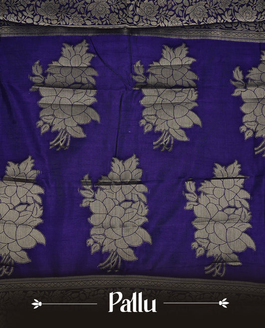 Indigo colour semi Tussar silk saree featuring an elegant plain body, complemented by a self colour border adorned with traditional gold zari floral kodi patterns. Comes paired with a matching blouse piece.