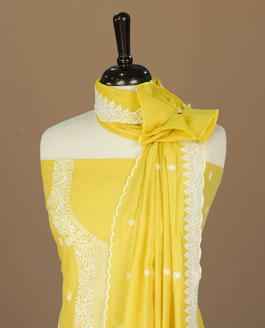 Yellow colour churidhar material featuring cream colour floral thread pattern on body, paired with matching bottom and Dupatta.