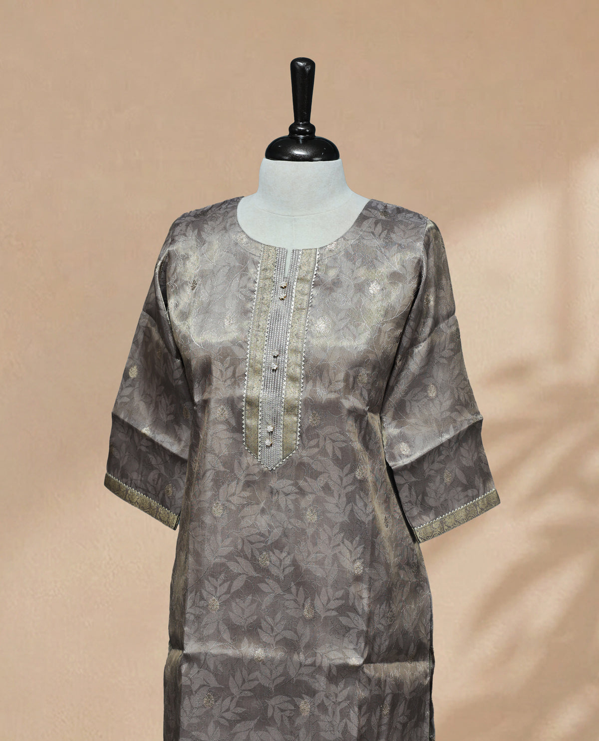 Grey colour Kurti featuring an intricate floral pattern, a round neckline adorned with detailed Stone & thread work, and 3/4 sleeves Design