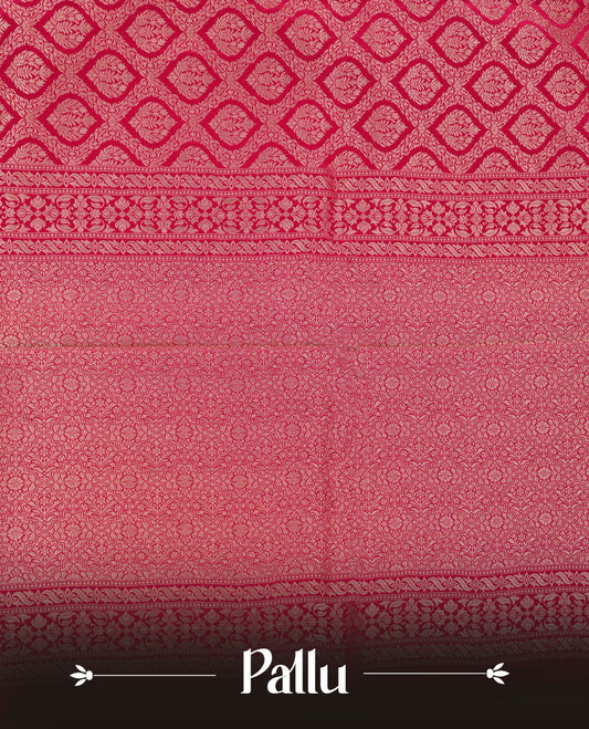 Rani pink colour banaras satin crepe saree featuring gold zari pattern across body, with self colour border with gold zari pattern and paired with matching blouse.