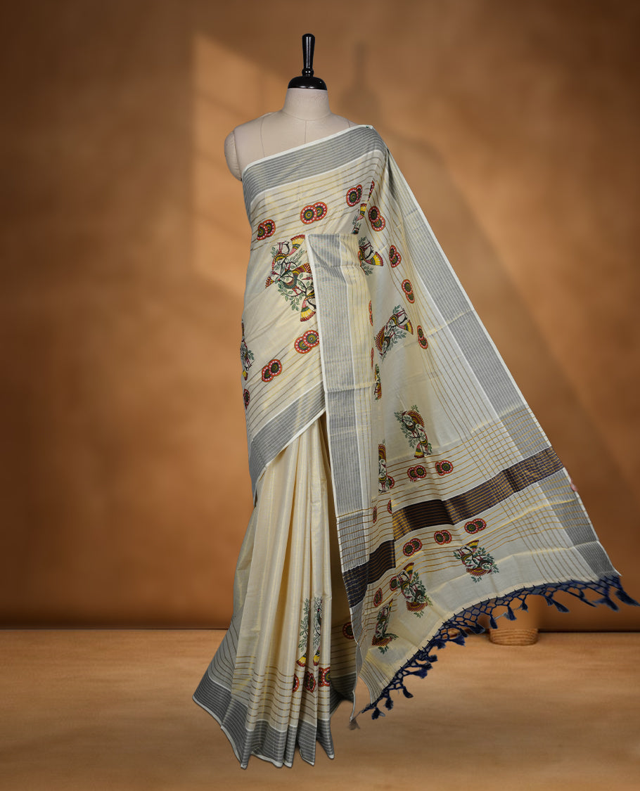 Light gold colour Tissue Kerala saree featuring a Plain body, an intricately woven gold and blue traditional pallu and border with chakra and peacok pattern paired with a matching blouse.