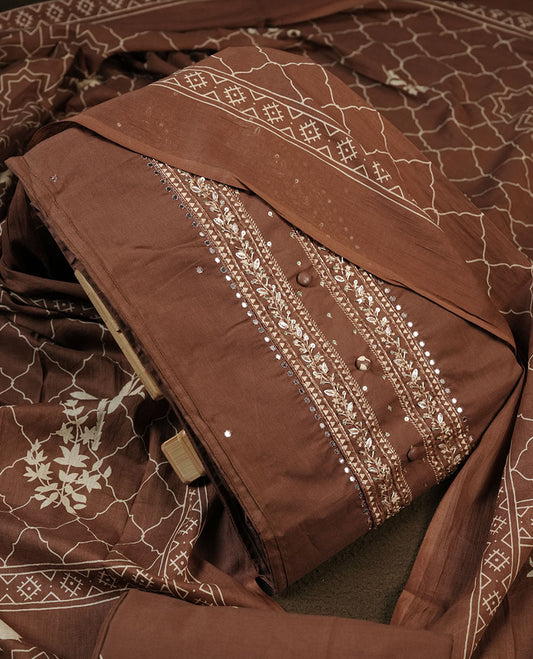 Chocolate brown colour churidar material featuring delicate thread embroidery with subtle mirror accents on the front panel, paired with a printed dupatta and matching bottom.
