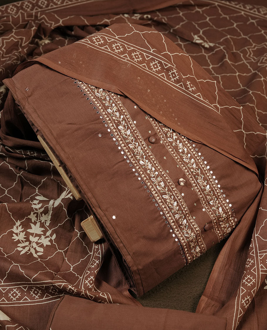 Chocolate brown colour churidar material featuring delicate thread embroidery with subtle mirror accents on the front panel, paired with a printed dupatta and matching bottom.