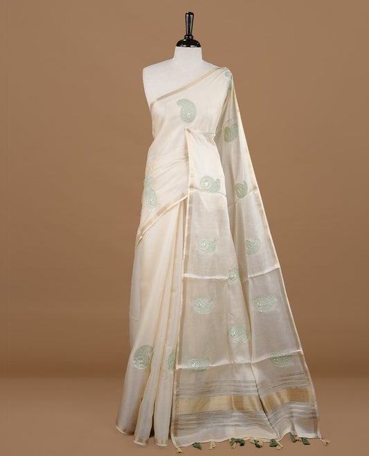 Cream colour Tussar saree featuring Light olive colour Mango pattern with chikankari embroidery work, highlighting gold zari simple border, paired with matching unstitched blouse.