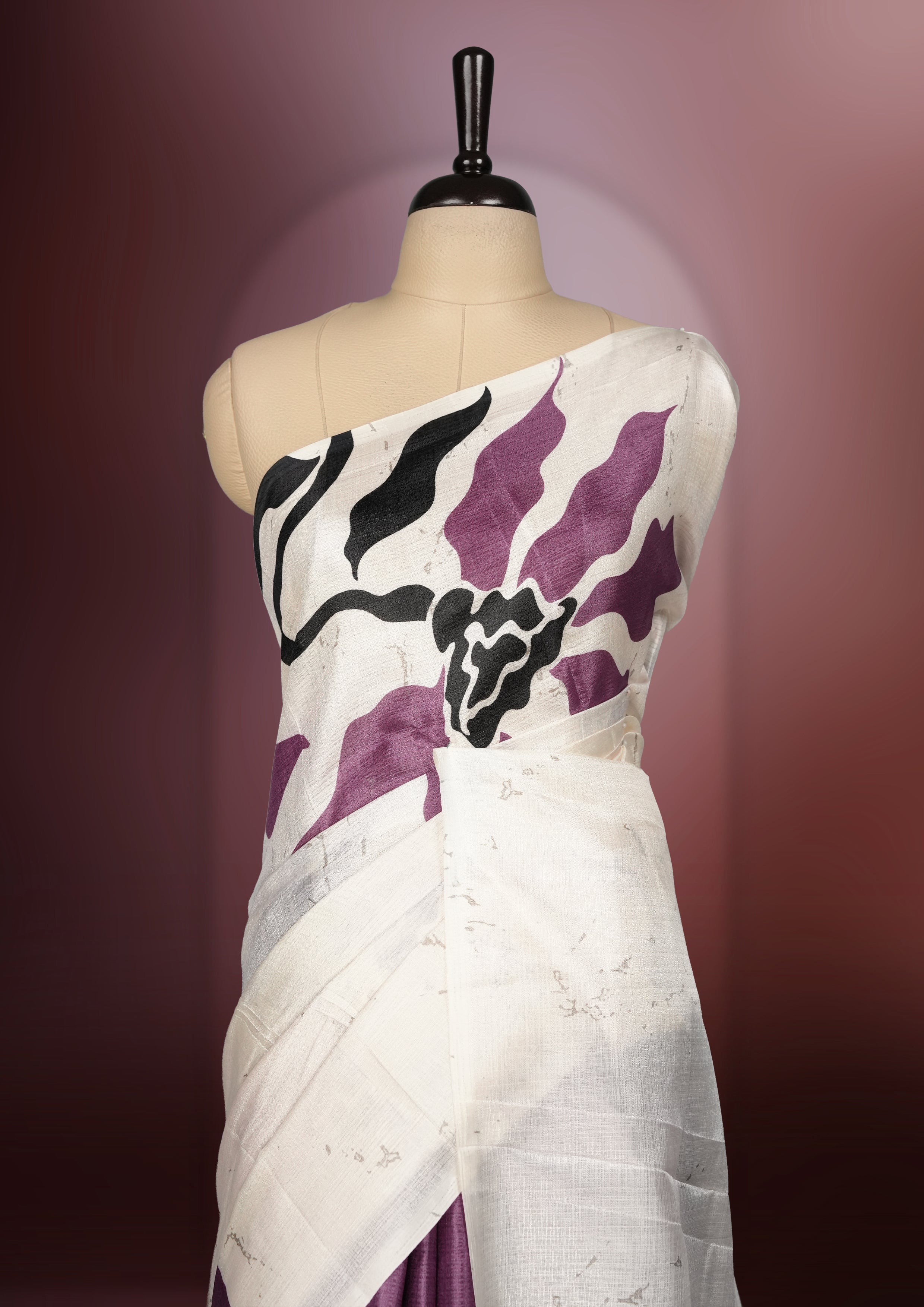 Onion pink and off white saree featuring striking black floral prints across the body, offering a chic and elegant appeal & Soft, lightweight fabric ensures graceful drapes, paired with a matching blouse.