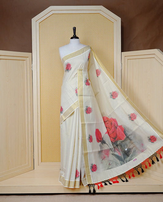 Cream Colour Tissue Kerala  Saree Featuring A Digital  Rose Printed Body &  Pallu ,  Beautifully Enhanced With A Classic Gold Zari Border And  Black & Red  Tassels, Paired With A Matching Blouse Piece.