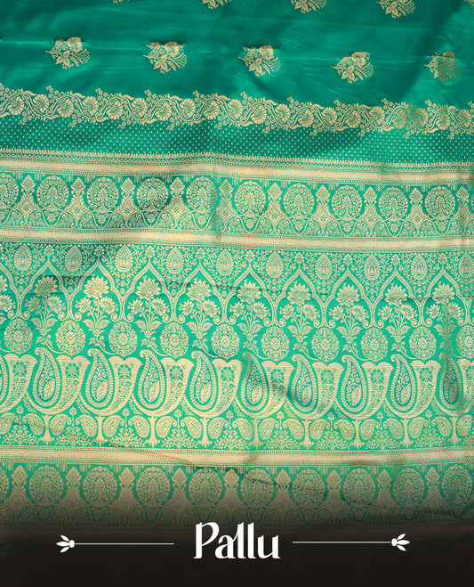 Green colour Banaras Satin Crepe saree featuring gold zari floral motifs on the body, a richly woven traditional border with intricate gold zari detailing, and paired with a matching blouse.