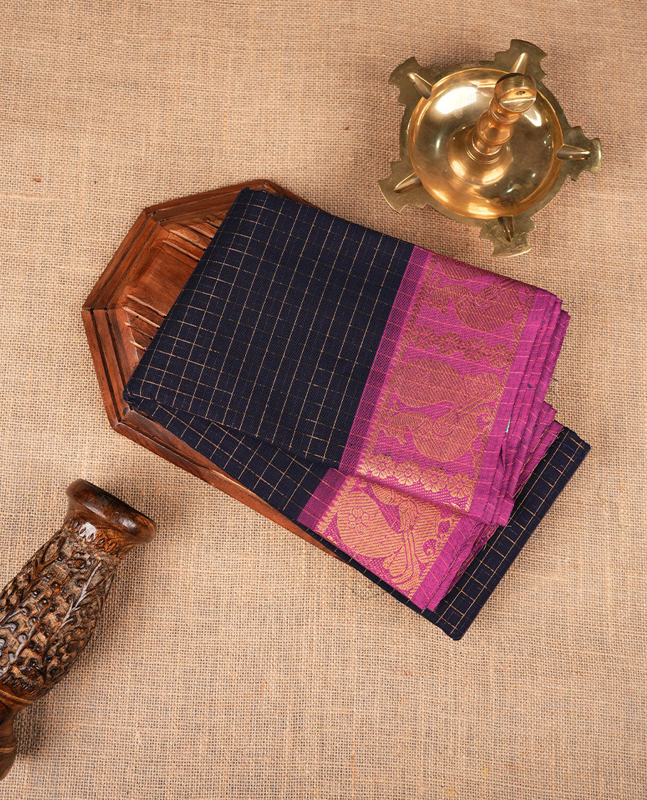 Navy blue colour sungudi cotton saree featuring gold zari check pattern across body, contrast Magenta colour with gold zari peacock and floral pattern on border, without blouse piece.