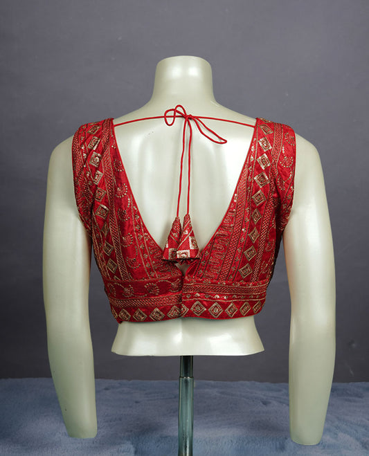 Red colour embroidered sleeveless blouse with intricate geometric motifs, deep V neckline, and tie-up back detailing for a chic finish.