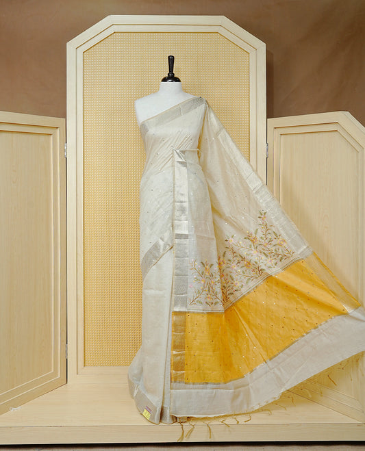 Cream Colour Tussar Kerala Saree Featuring Elegant Mirror Work on the Body, Enhanced with a Light Gold Zari Border, Floral Thread Work, and a Yellow & Gold Zari Pallu, Paired with a Matching Blouse Piece