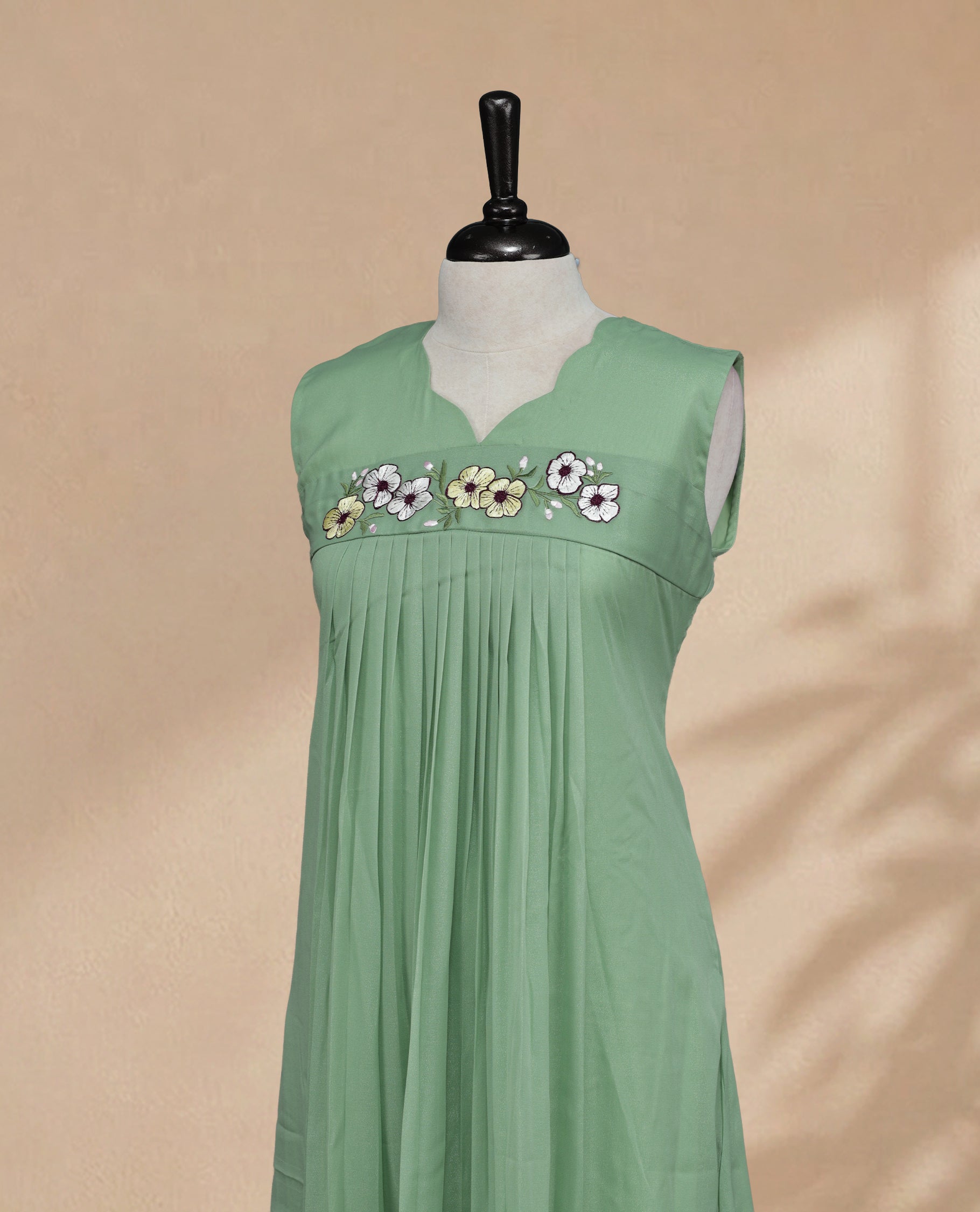 Pista Coloured Sleeveless Kurti Featuring a Designed Neckline, Floral Embroidery on the Body