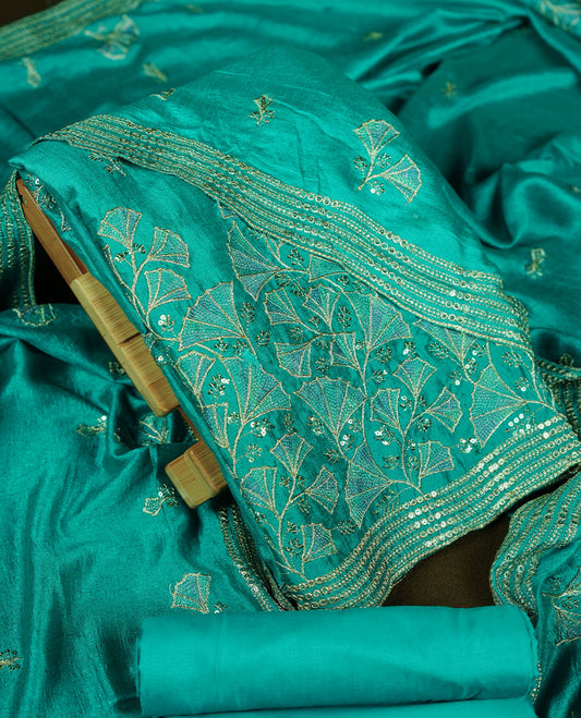 Teal colour churidar material with subtle mirror and thread embroidery, finished with delicate border detailing and paired with a matching plain bottom and dupatta.