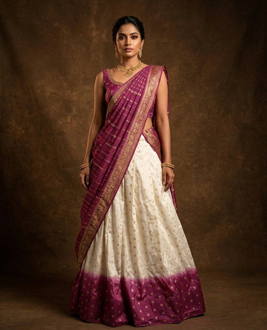 Off White colour semi stitched half saree material featuring delicate zari buttas on the blouse and skirt, paired with a contrast pink zari border and matching striped dupatta