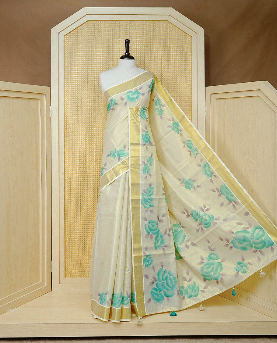 Cream Colour Tissue Kerala Saree Featuring Digital  Mind Rose Prints Across The Body, Enhanced With A Gold Zari Border , Finished With Mind & Cream Tassels And A Matching Blouse Piece