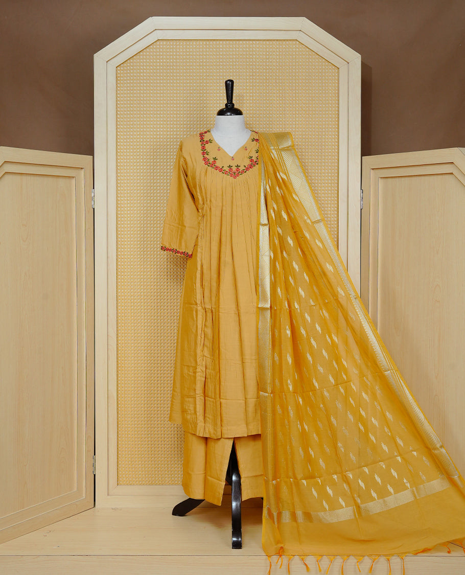 Mustard yellow colour churidar set with floral thread embroidery along the V-neckline and sleeve cuffs, pleated detailing on the front, paired with a matching dupatta and solid pants.