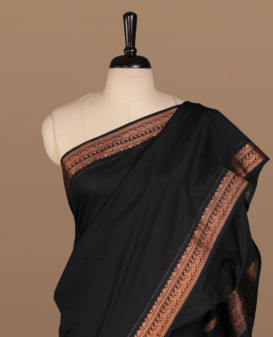 Black colour kalyani cotton saree featuring Elegant plain body, complemented by selfcolour with Antique zari border, paired with matching blouse piece.
