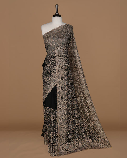 Black colour georgette designer saree featuring Gold thread floral pattern on body highlighting with stone and scalp border, paired with matching blouse piece.