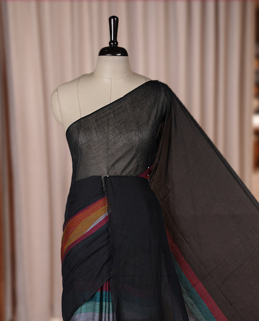 Black colour soft cotton saree with rainbow colored horizontal lines on the body, a vibrant multicolor pallu, and a subtle border & Elegant and lightweight, this saree comes without a blouse piece for a customizable style.