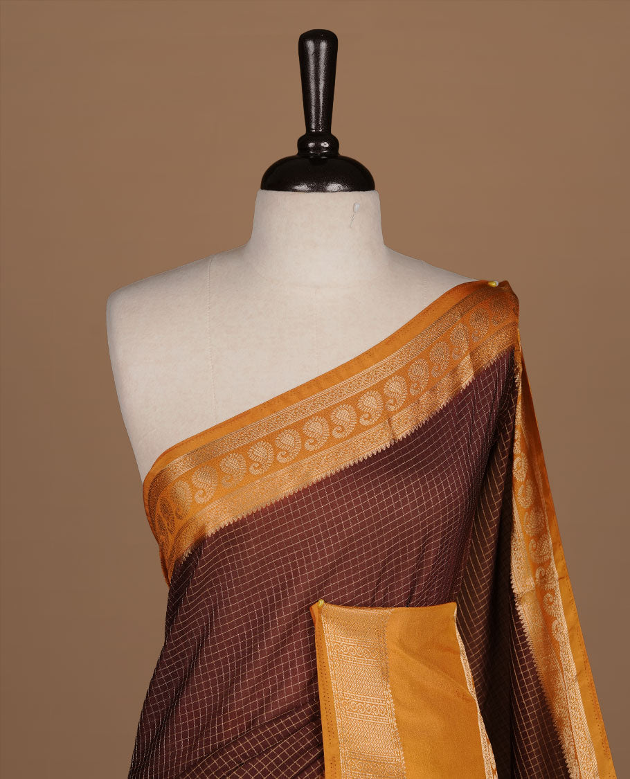 Chocolate colour semi georgette saree featuring gold zari check pattern on body, complemented by contrast Mustard colour with zari border, paired with matching blouse piece.